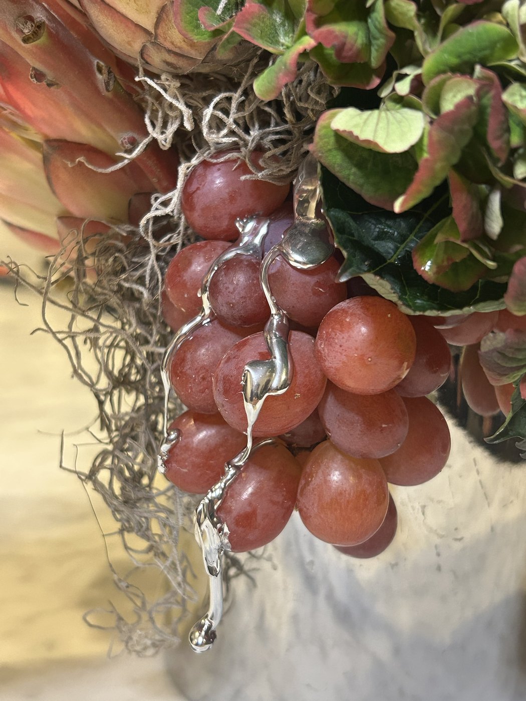 Close-up of silver dripping over a cluster of red grapes (photo 3 of 4)